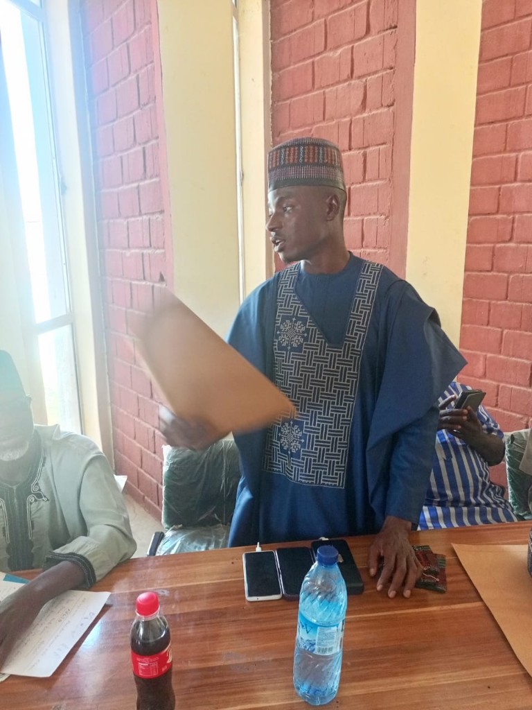 Hon. Aminu Musa pauses at the table as the conversation continues.