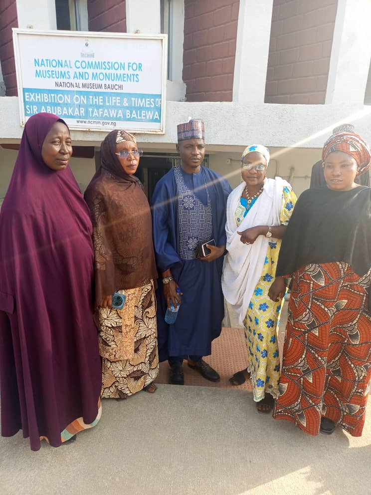 A group portrait in front of the sign for the Sir Abubakar Tafawa Balewa exhibition.